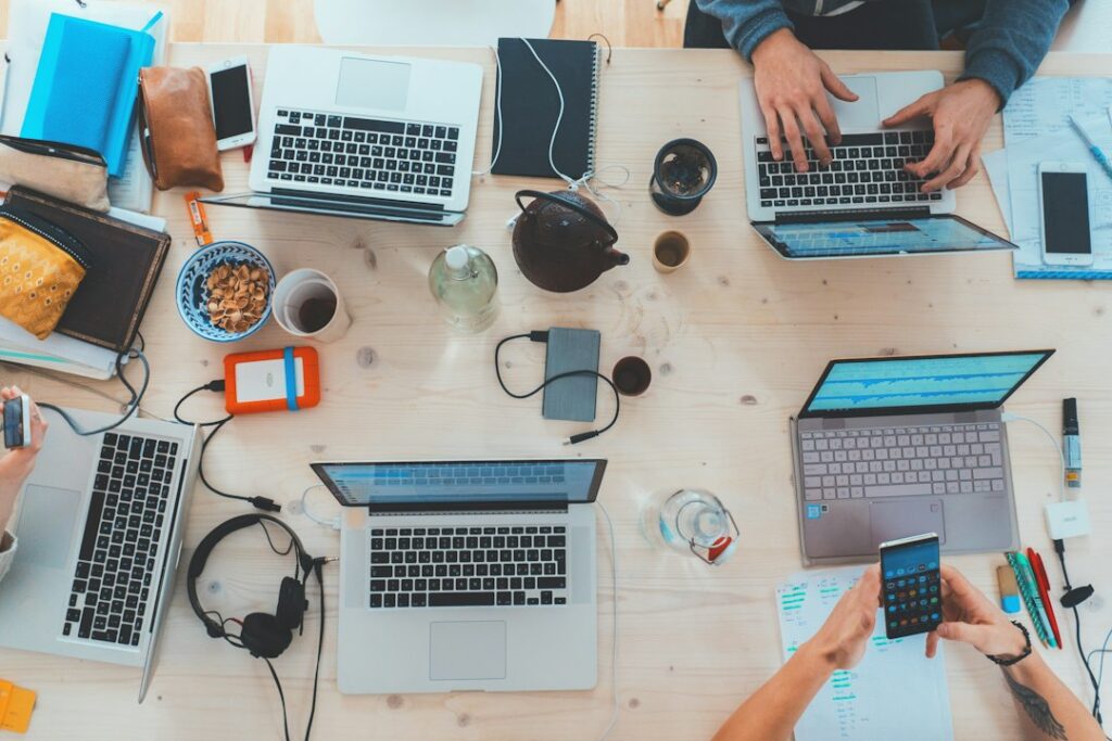 Equipo profesional reunido con ordenadores portátiles aprendiendo competencias digitales